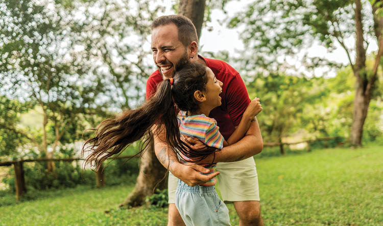 Father embracing daughter on the public park
